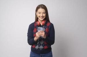 Young asian woman using smartphone over white background, technology concept. photo