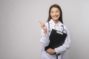 retrato de una doctora segura de sí misma sobre un estudio de fondo blanco, concepto de tecnología médica y asistencia sanitaria. foto