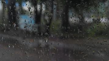 gotas de lluvia en el cristal. las gotas fluyen por el primer plano de cristal. foto