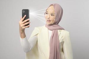 Beautiful woman is scanning her face with facial recognition system Smart phone photo