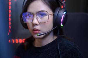 close up of professional Streamer and gamer wearing glasses playing online video games  with monitor reflection in glasses photo