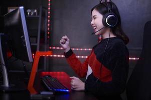 Young female professional Streamer and gamer with headset playing online video games photo