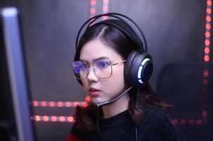 Young female professional Streamer and gamer with headset playing online video games photo