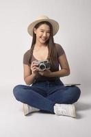 Young happy asian tourist woman over white background studio, travel and holidays concept. photo