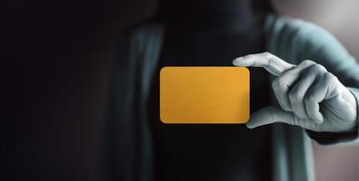 Business Card Mockup Image. Woman Holding a Blank Gold Card. Raised into the Camera. Selective focus. Front View photo