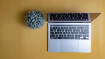 computer laptop on yellow background. Copy space photo