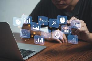 Concepto de negocio de inteligencia bi de análisis de datos grandes con iconos de gráficos y gráficos en la interfaz y un hombre de negocios sosteniendo un lápiz tocando la pantalla virtual. foto