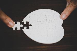 Business woman person hand with puzzle piece idea for strategy and solution. Closeup part of two white jigsaw connect together. Concept of join cooperation success teamwork-problem corporate team. photo