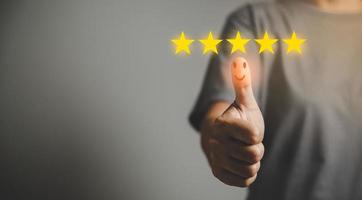 Hand with thumb up positive emotion smiley face icon and 5 star with copy space. Emotional smiley faces showing excellent satisfaction. rating very impressed. Customer service and satisfaction concept photo