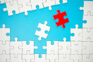 White part of jigsaw puzzle pieces on blue background. concepts of problem solving, business success, teamwork, Team playing jigsaw game incomplete, Texture photo with copy space for text