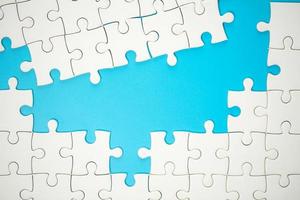 White part of jigsaw puzzle pieces on blue background. concepts of problem solving, business success, teamwork, Team playing jigsaw game incomplete, Texture photo with copy space for text