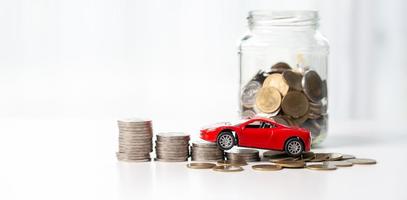 Car toy vehicle with stack coin money on background. Planning to manage transportation finance costs. Concept of car insurance business, saving buy - sale with tax and loan for new car. photo