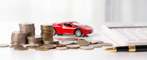 Car toy vehicle with stack coin money on background. Planning to manage transportation finance costs. Concept of car insurance business, saving buy - sale with tax and loan for new car. photo