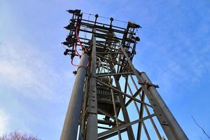 Electric antenna and communication transmitter tower in a northern european landscape against a blue sky photo