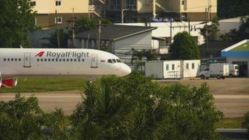 PHUKET, THAILAND NOVEMBER 30, 2019 - Royal Flight Boeing 757 VQ BTB taxiing after landing at Phuket International airport, focus on a foreground palm trees video