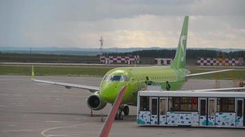 kazan, federación rusa 14 de septiembre de 2020 - tripulación del aeropuerto abriendo la escotilla de s7 airlines embraer e170 vq byv después de su llegada al aeropuerto internacional de kazan, vista desde la torre de control video