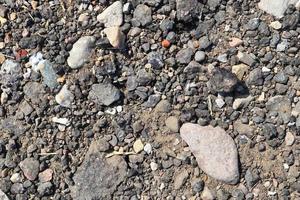 Detailed close up view on pebbles and stones on a gravel ground texture photo