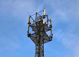 Antena eléctrica y torre transmisora de comunicaciones en un paisaje del norte de Europa contra un cielo azul foto