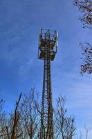 Electric antenna and communication transmitter tower in a northern european landscape against a blue sky