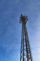 Electric antenna and communication transmitter tower in a northern european landscape against a blue sky photo