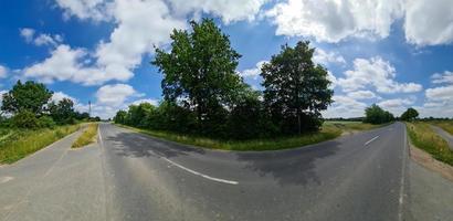 hermoso panorama de alta resolución de una carretera rural del norte de Europa con campos y hierba verde. foto