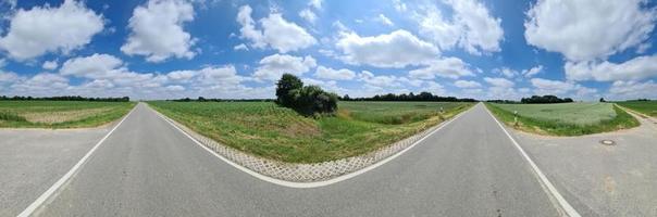 hermoso panorama de alta resolución de una carretera rural del norte de Europa con campos y hierba verde. foto