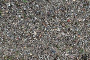 Detailed close up view on pebbles and stones on a gravel ground texture photo