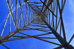 Antena eléctrica y torre transmisora de comunicaciones en un paisaje del norte de Europa contra un cielo azul foto