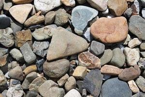 Detailed close up view on pebbles and stones on a gravel ground texture photo