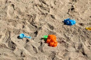 coloridos juguetes de plástico para niños en un arenero en un campo de juego. foto