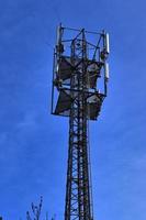 Antena eléctrica y torre transmisora de comunicaciones en un paisaje del norte de Europa contra un cielo azul foto