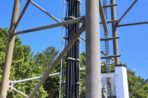 Electric antenna and communication transmitter tower in a northern european landscape against a blue sky photo