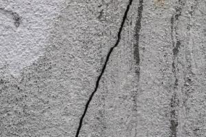 Detailed close up view on aged concrete walls with cracks and lots of structure photo
