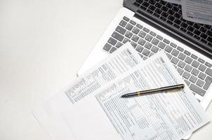 office desk with tax forms, laptop and pen, business concept background photo