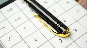 Financial accounting with calculator and pen on wooden desk photo