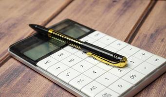 Financial accounting with calculator and pen on wooden desk photo