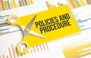 policies and procedure word written on yellow notebook and charts photo