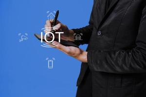 Internet of Things IoT concept. Business people press IoT solutions with symbols connected to common IoT icons. photo