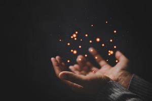 mano de persona de oración en fondo negro. la mujer católica cristiana está rezando a dios en la oscuridad en la iglesia. chica cree y fe en jesucristo. la religión de cristo y el cristianismo adoran o rezan concepto. foto