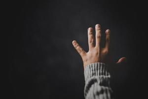 Prayer person hand in black background. Christian catholic woman are praying to god in dark at church. Girl believe and faith in jesus christ. Christ religion and christianity worship or pray concept. photo