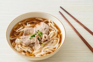 homemade udon noodles with pork in soy or shoyu soup photo