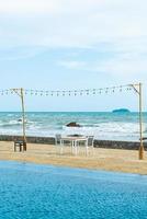 dinning table and chair on beach with sea background photo