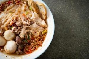 noodles with pork and meatballs in spicy soup photo