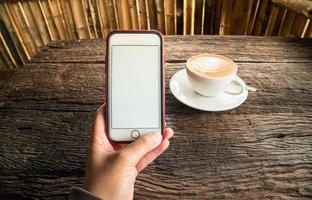 Man holding mobile phone on his hand in the cafe shop. photo