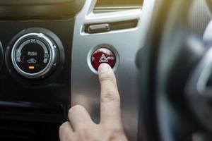 Finger press the emergency button in the car. photo