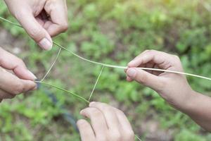 Mother and daughter hands hold the grass to tear the square to resemble an imaginary movie screen playing in the lawn. Activities to strengthen family relationships. photo