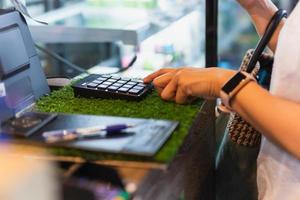 mujer costomer ingresa la cantidad en la caja registradora en el café. foto