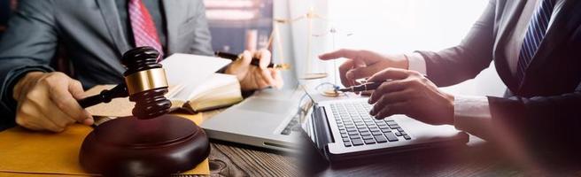 Business and lawyers discussing contract papers with brass scale on desk in office. Law, legal services, advice, justice and law concept picture with film grain effect photo