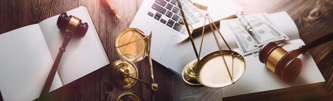 Justice and law concept.Male judge in a courtroom with the gavel, working with, computer and docking keyboard, eyeglasses, on table in morning light photo