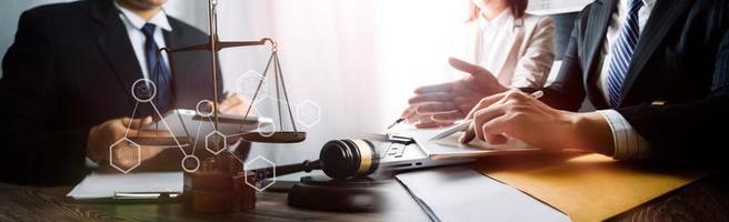 Justice and law concept.Male judge in a courtroom with the gavel, working with, computer and docking keyboard, eyeglasses, on table in morning light photo